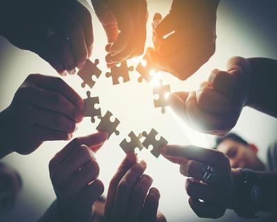 People in a circle holding jigsaw pieces